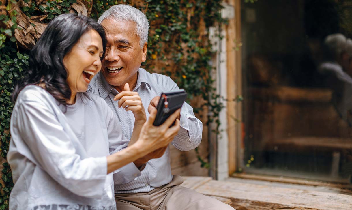 couple sitting looking at phone