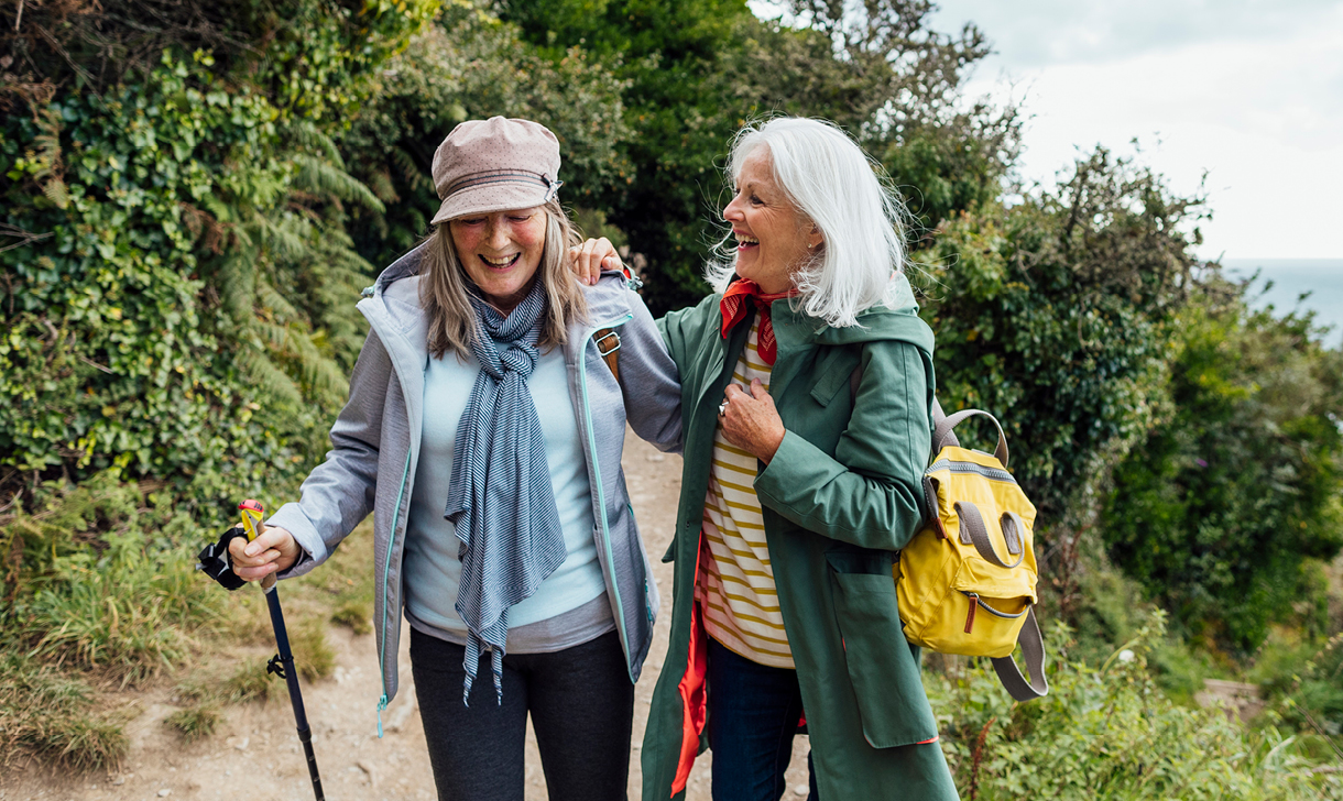 two senior women hiking on trail