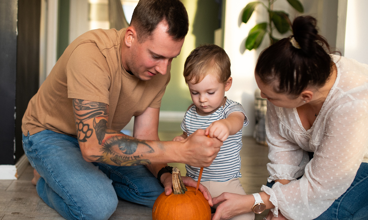 young family carving pumpkin