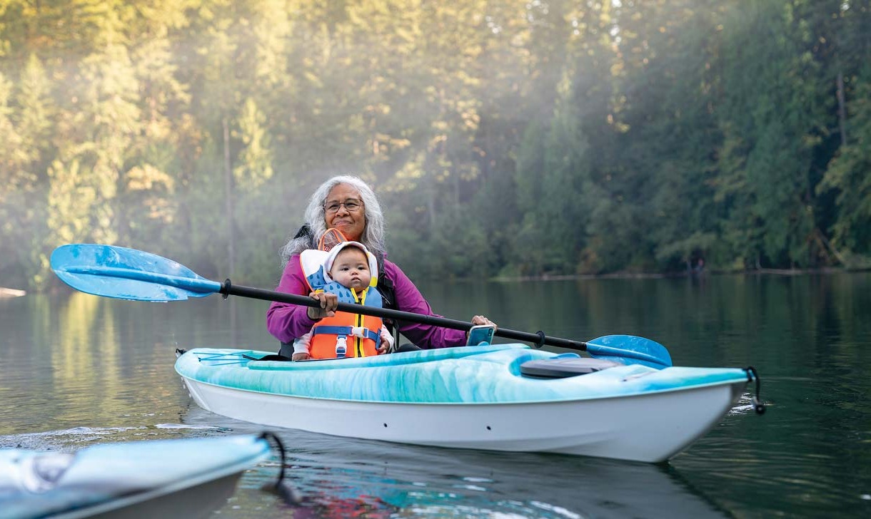 Senior woman canoeing with baby