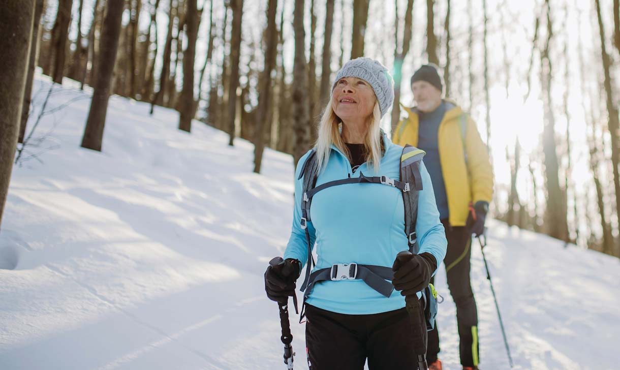 senior couple snowshoeing in snowy forest