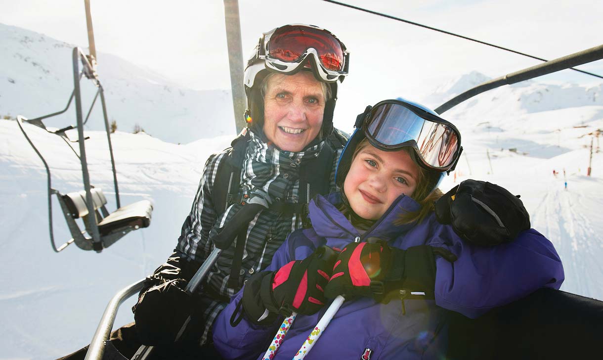 senior woman on ski lift with granddaughter