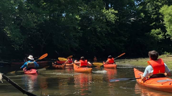Apex Youth group kayaking across a river