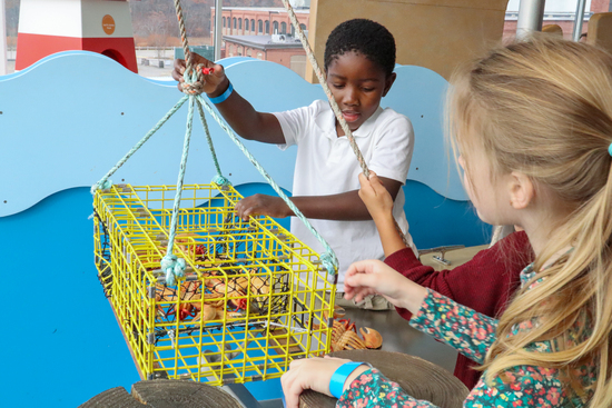 boy playing with museum employee