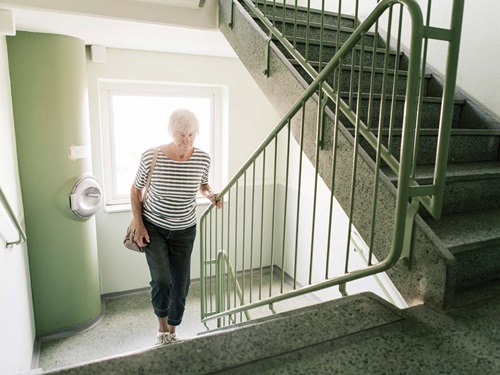 elder woman walking up stairs
