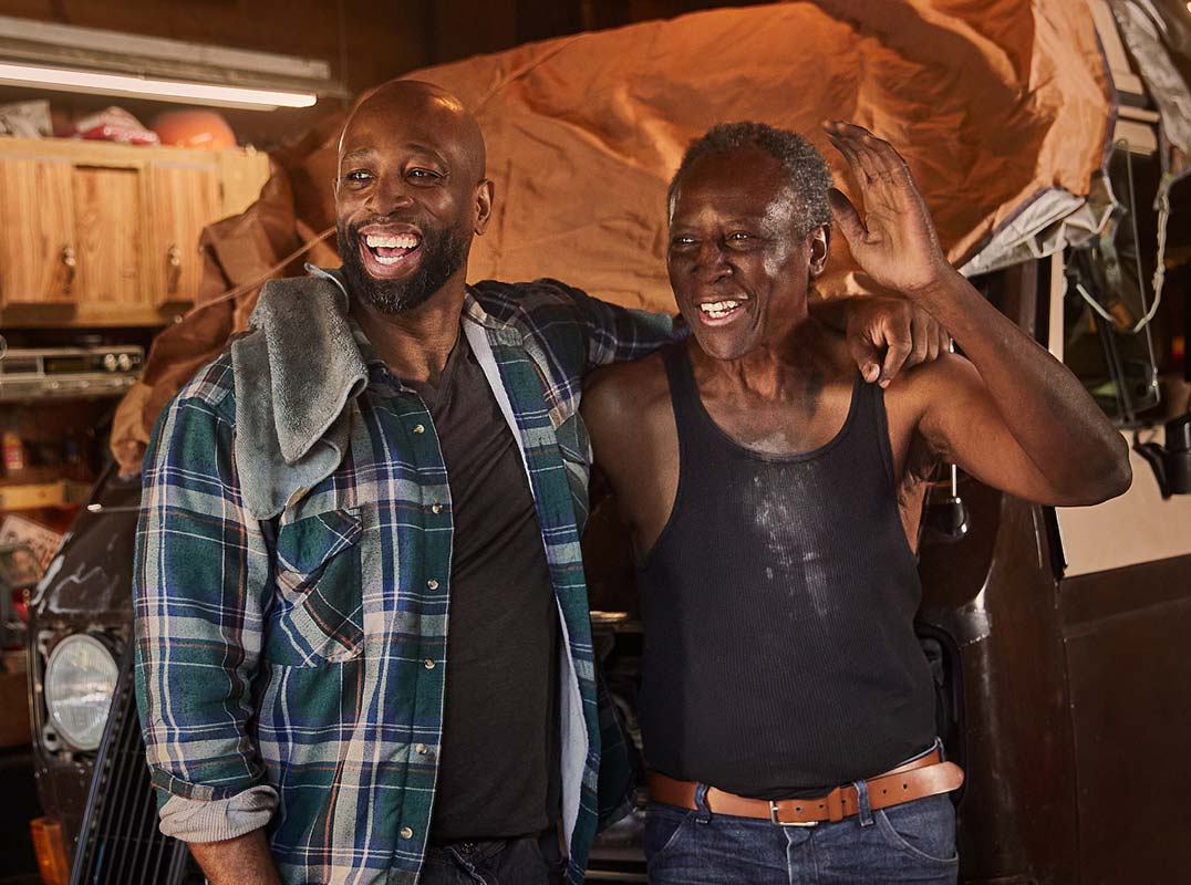 two men working on cars in a garage