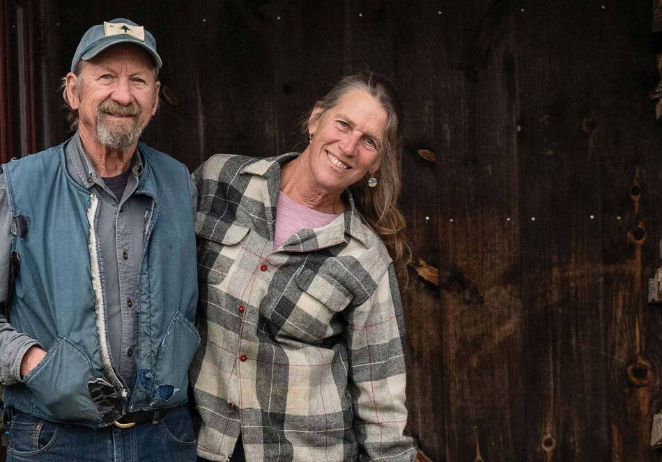 senior couple smiling in woodshed