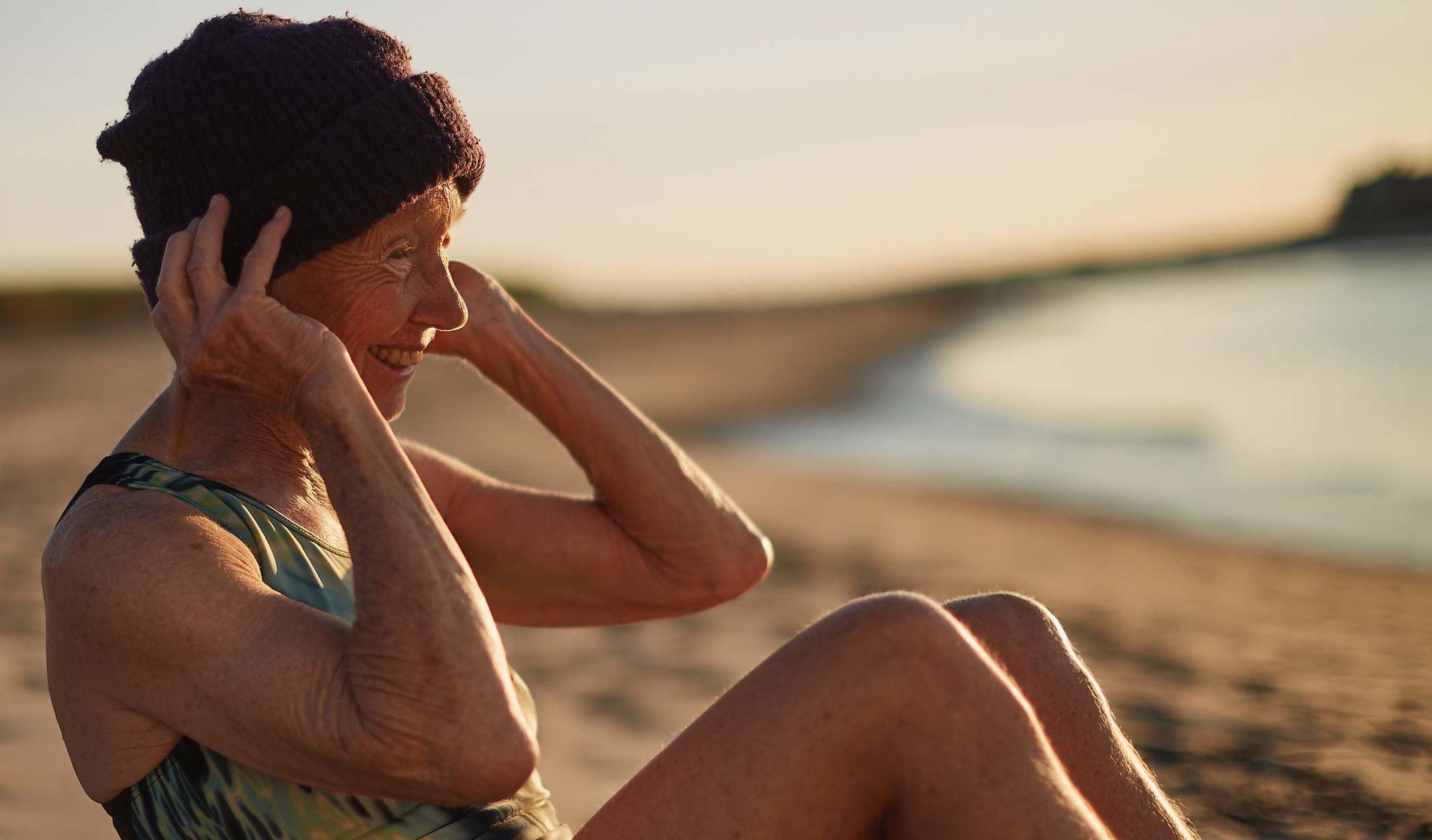 senior woman on beach with morning sunrise