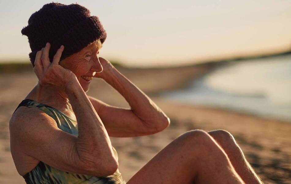 senior woman on beach with morning sunrise