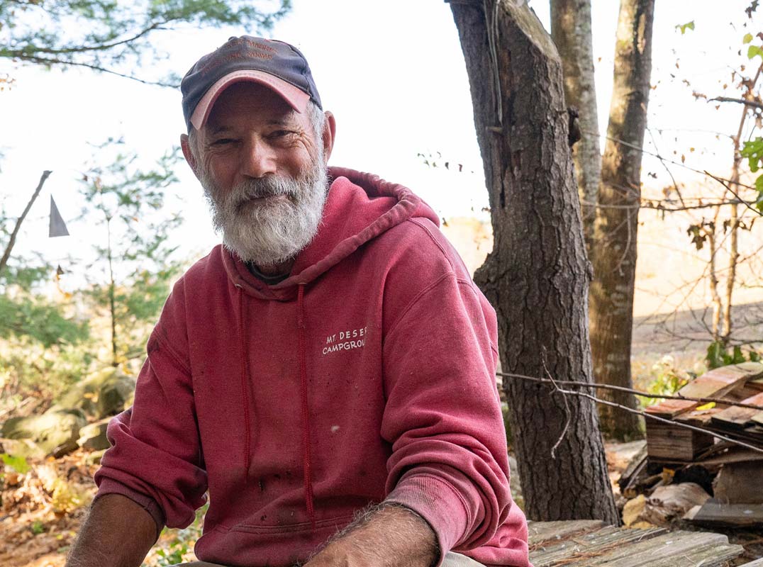 senior man outside at a lakeside cabin