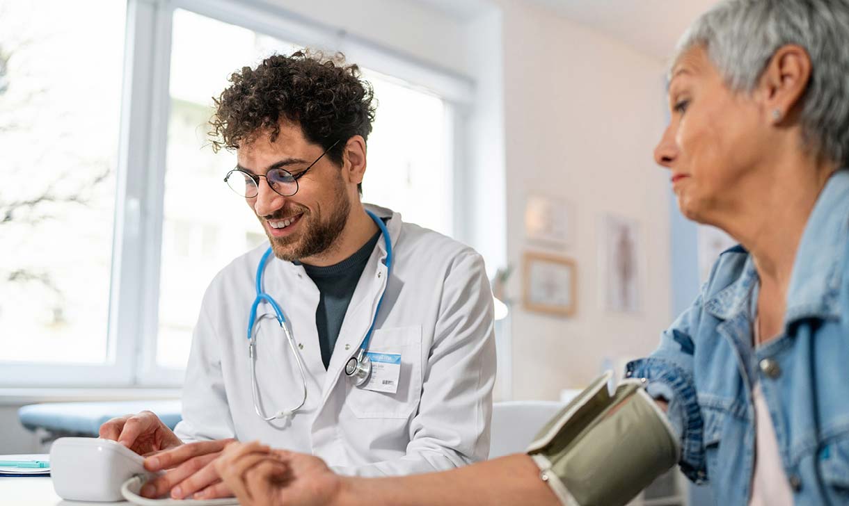 doctor taking patient's blood pressure