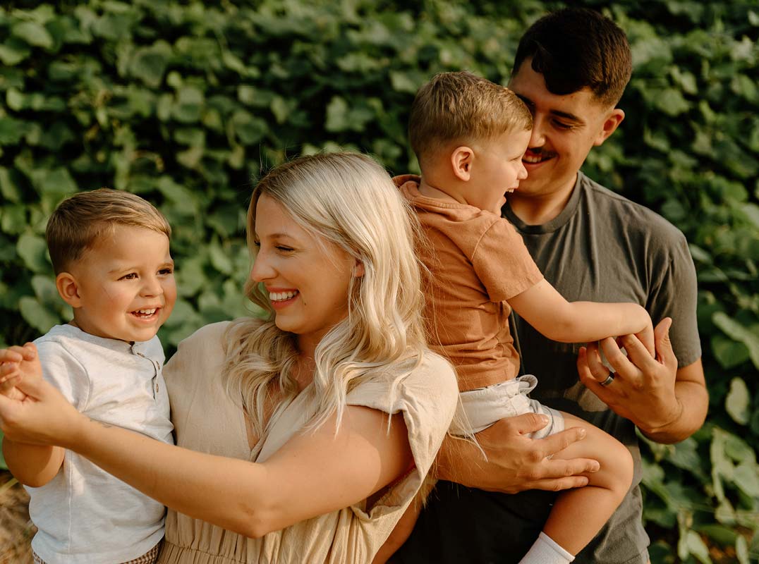 young family outside in nature laughing