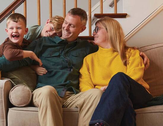 parents with two young boys on sofa