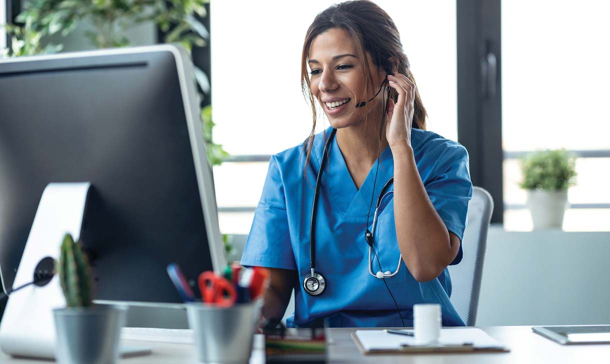 Female doctor talking on the phone while working at her desk.