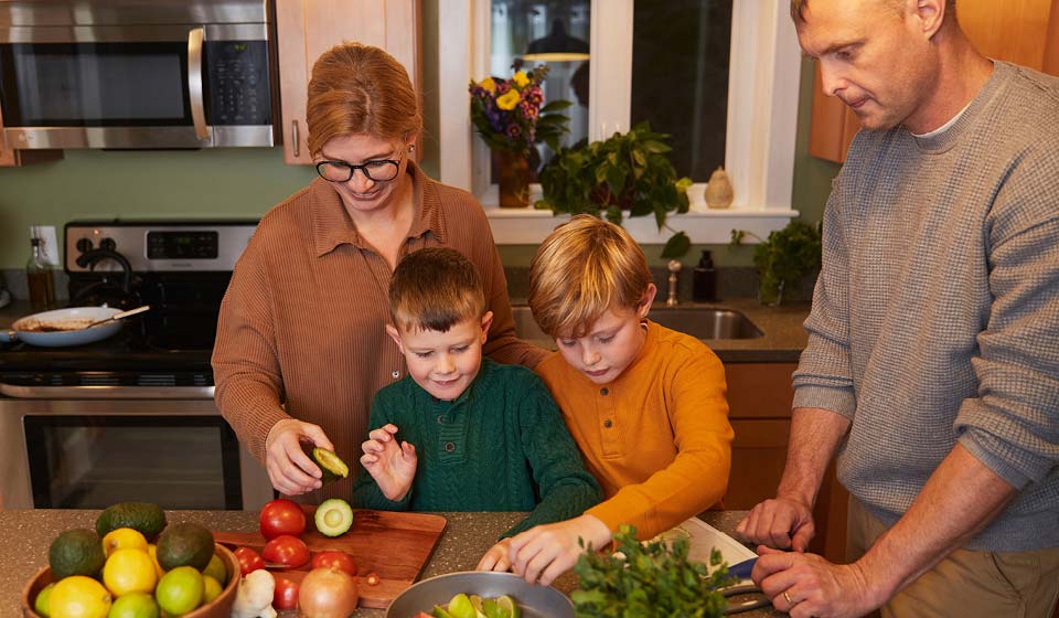 Family cooking together in a warm, inviting kitchen.