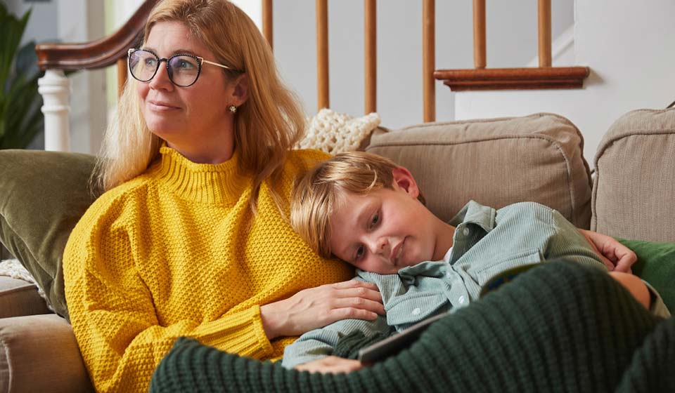 Mother and son relaxing together on a cozy couch at home.