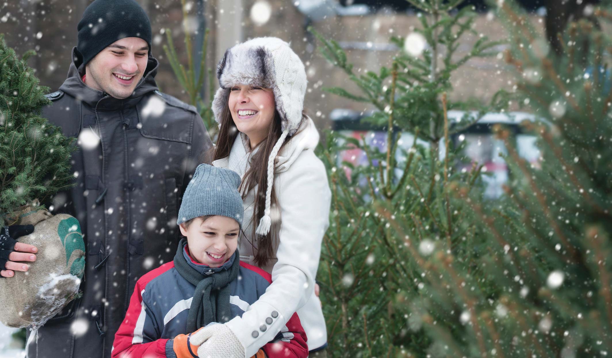 Family standing outdoors in the snow with a young child.