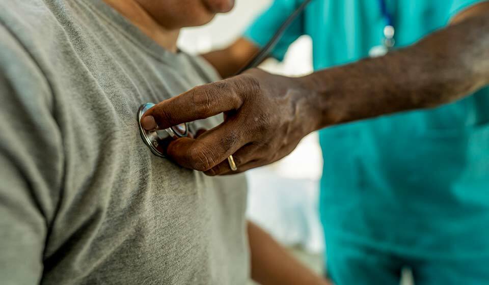 Doctor listening to a patient’s chest with a stethoscope.