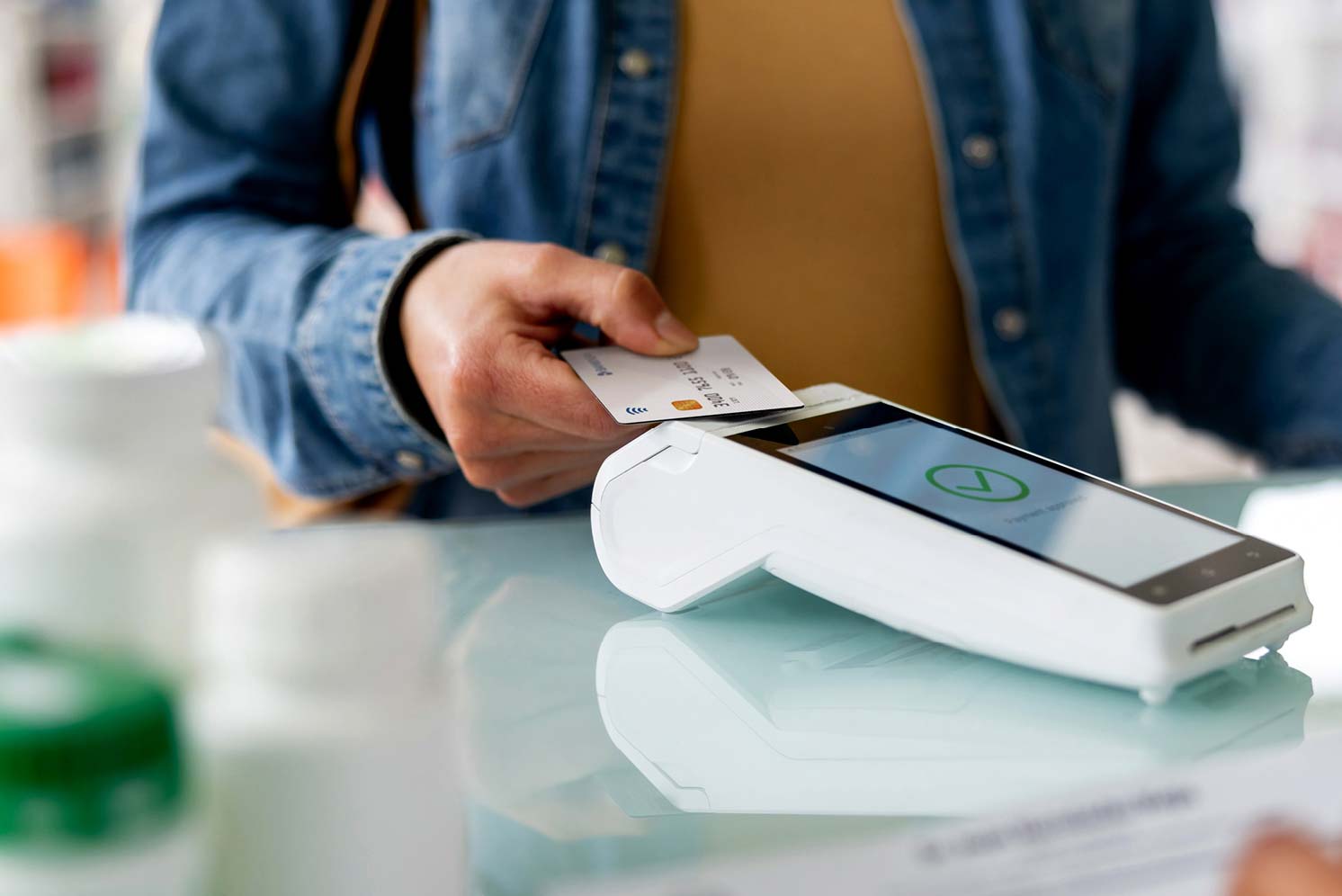 Person using a payment card at a pharmacy counter