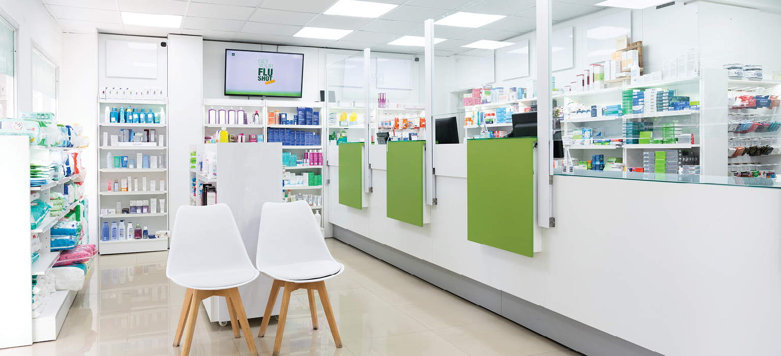 Clean, bright pharmacy interior with chairs and medication shelves.